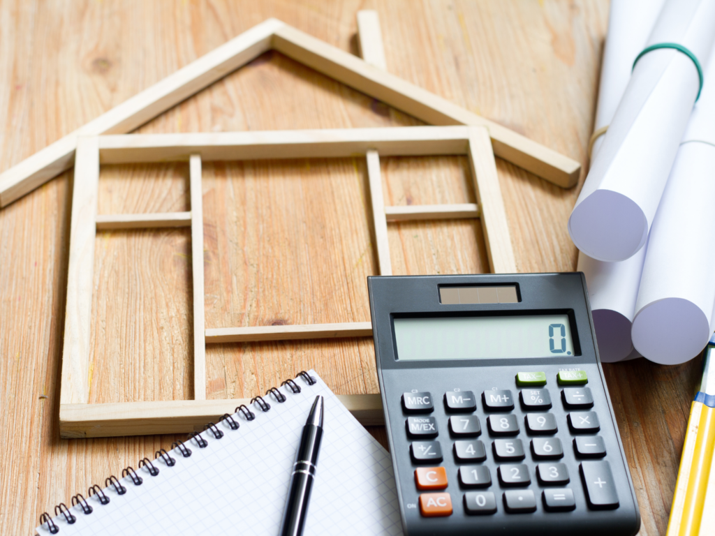 Plano de vivienda, calculadora y libreta para preparar un presupuesto de reforma