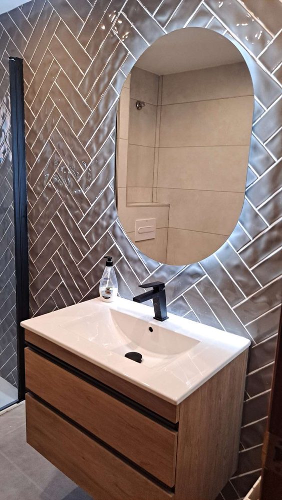 Mueble de lavabo de madera con grifería negra y espejo ovalado