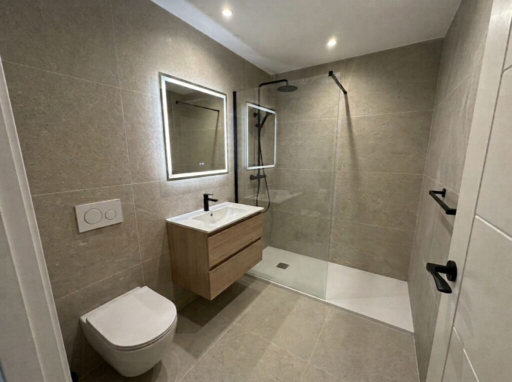 Baño reformado con plato de ducha, mampara y mueble suspendido